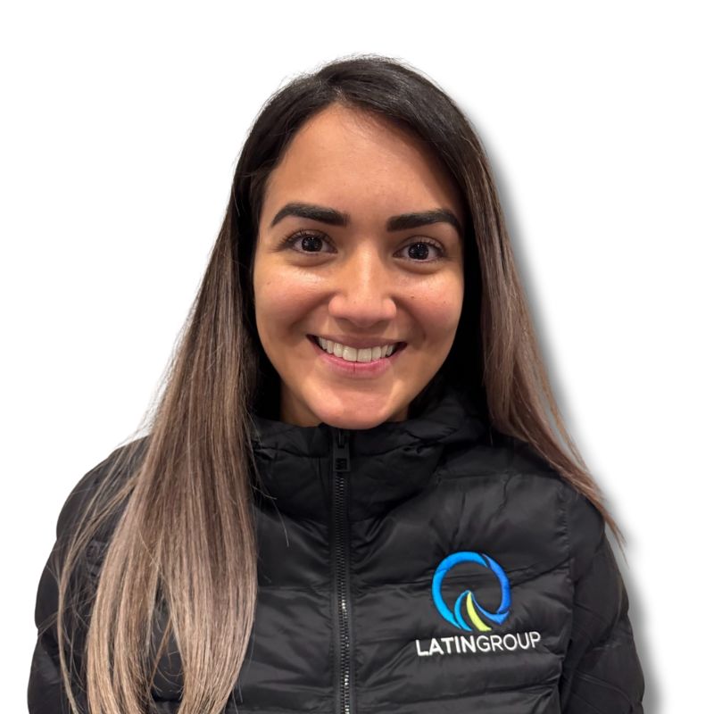 A woman smiles at the camera, wearing a black jacket adorned with the Latin Grup Commercial Cleaning logo. The background is crisp and white.