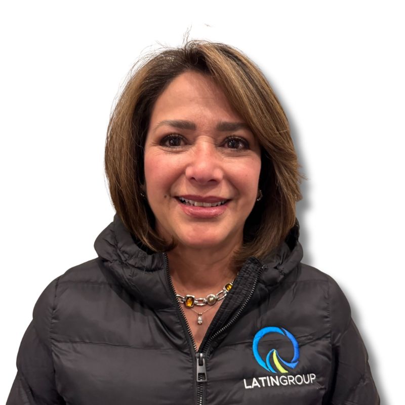 A woman with shoulder-length hair is smiling, wearing a black jacket featuring a logo and the text "LATINGROUP." The backdrop is plain white, highlighting her association with Latin Grup's commercial cleaning services.