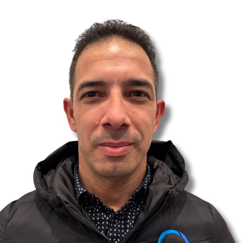 Man with short dark hair, donning a black jacket and patterned shirt, exudes professionalism against a plain white background—a fitting image for Latin Grup's excellence in commercial cleaning.