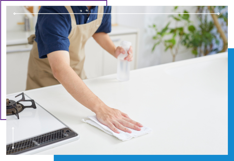 a professional cleaner wiping down a counter next to a stove