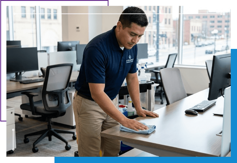 commercial cleaner wiping down a desk