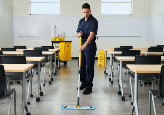 Educational facility cleaning team disinfecting classroom desks to improve student safety and attendance
